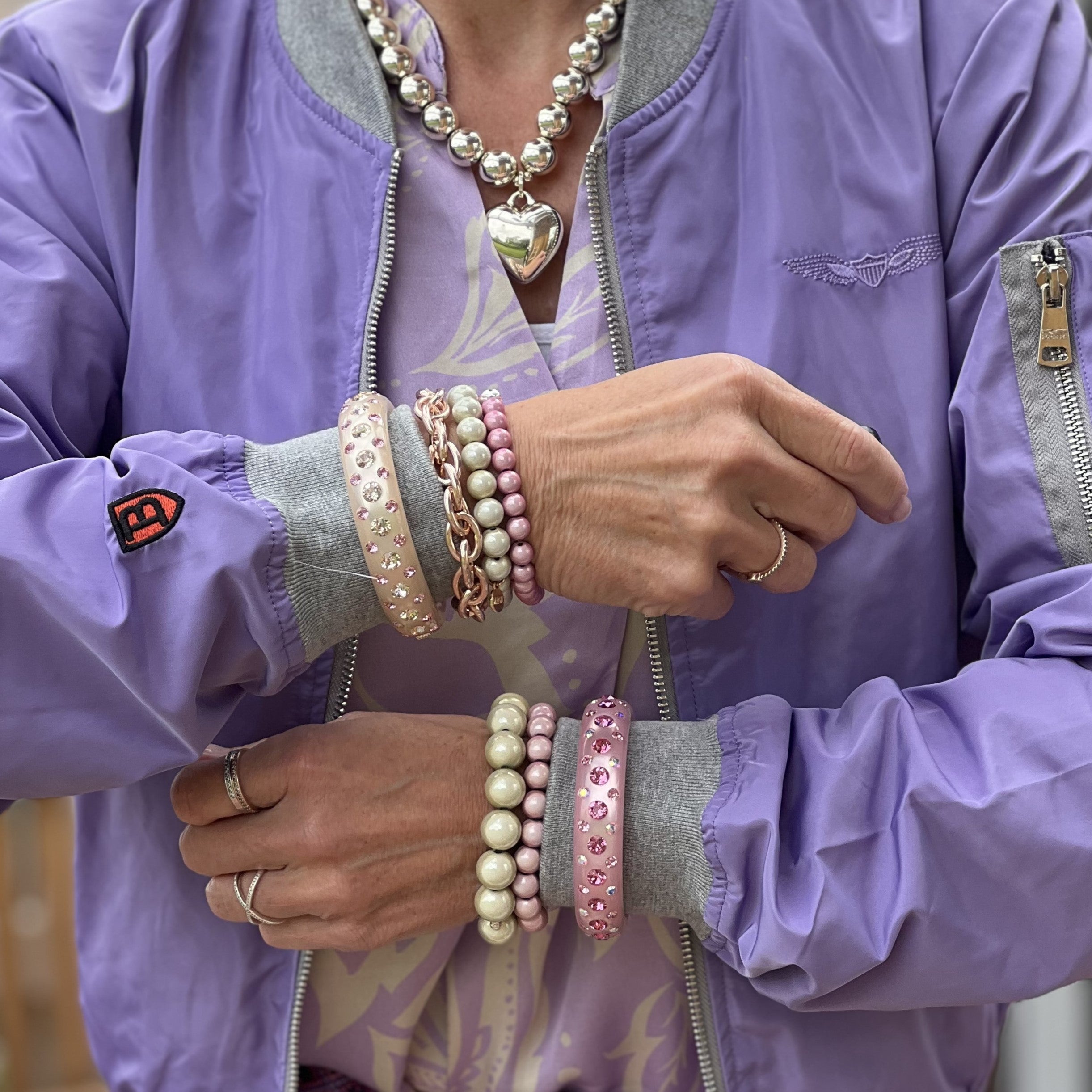 Hand mit bunten Coloristers Armreifen mit Kristallen. Hand with colourful Coloristers bangles with crystals. 